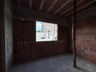 Ambiente interno com paredes de tijolo aparente e estrutura de concreto.