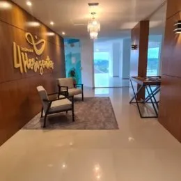 Hall de entrada com painéis de madeira e móveis de assento.