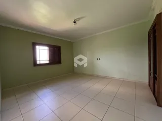 Ambiente interno de uma sala com piso de cerâmica e janela.