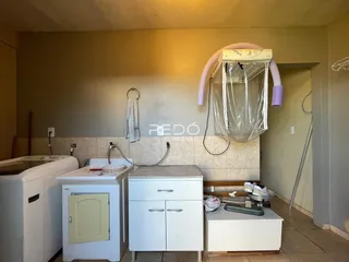 Interior de uma cozinha com bancada e armários brancos.