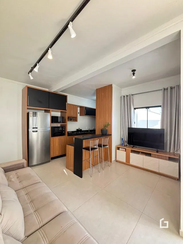 Sala de estar moderna com móveis de madeira e piso claro.