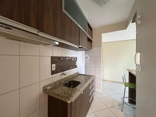 Cozinha com armários de madeira e revestimento branco.