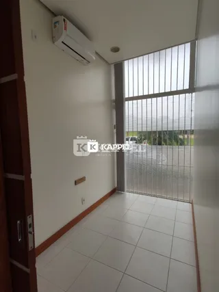 Foto de um cômodo interno com piso de cerâmica e uma grande janela.