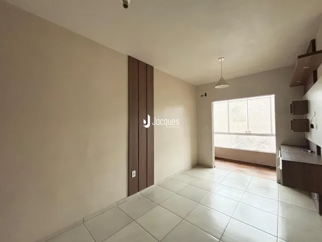 Sala de estar com piso de cerâmica e painel de madeira na residência.