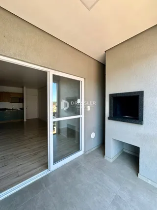 Vista interna de uma sala com porta de vidro e parede de lareira.