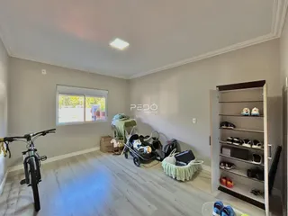 Uma sala de estar com piso de madeira clara e janela.