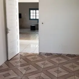 Vista de um piso de ladrilhos em um corredor interno.