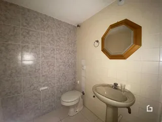 Banheiro com revestimento de cerâmica nas paredes e louças sanitárias.