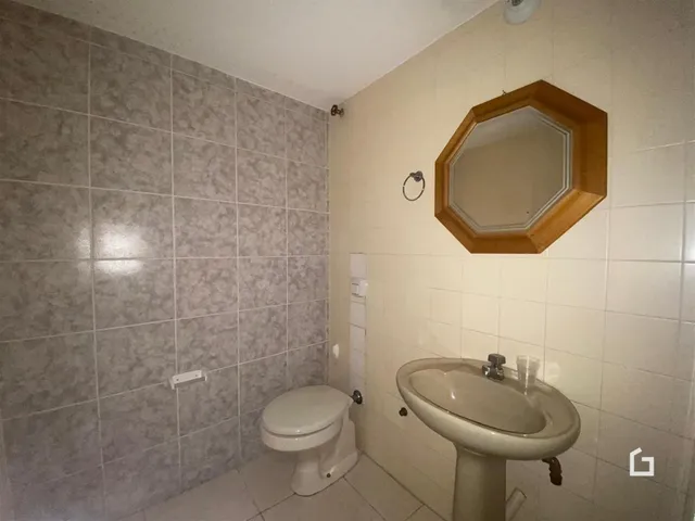 Banheiro com revestimento de cerâmica nas paredes e louças sanitárias.