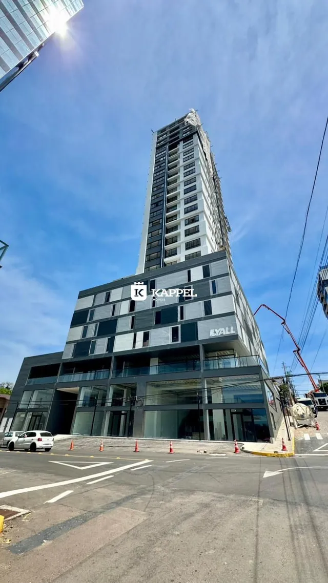 Fachada de um edifício alto em Lajeado, Brasil, sob um céu azul.