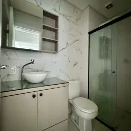 Foto de um banheiro com bancada e vaso sanitário.