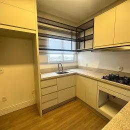 Foto de uma cozinha com armários claros e piso de madeira.