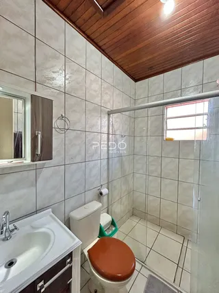 Foto de um banheiro com revestimento cerâmico e vaso sanitário.