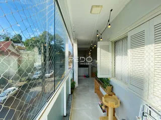 Hall de entrada com janelas e luz natural na residência.