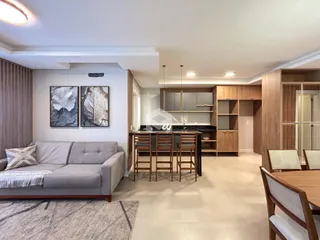 Sala de estar e cozinha integrada com decoração moderna.