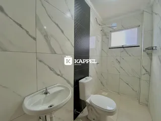 Foto de um banheiro com pia e vaso sanitário revestido com azulejos brancos.