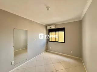 Uma sala de estar clara com piso de cerâmica e uma janela.