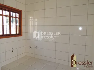 Parede interna com revestimento cerâmico e moldura de janela em um imóvel.