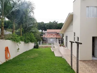 Vista da fachada de uma residência com jardim gramado.