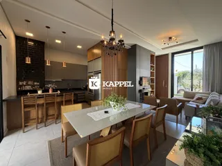 Uma foto de um ambiente aberto mostrando a cozinha e a sala de jantar de uma residência.