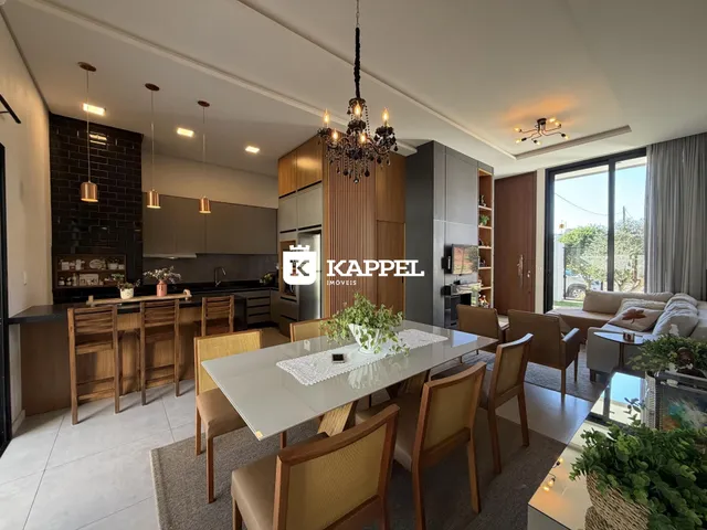 Uma foto de um ambiente aberto mostrando a cozinha e a sala de jantar de uma residência.