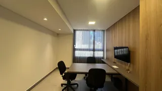 A sala possui uma mesa de jantar e uma grande janela com vista para o exterior.