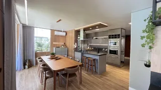 Interior de uma sala de jantar e cozinha moderna com piso de madeira.