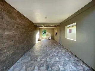 Corredor interno com paredes texturizadas e piso de cerâmica.