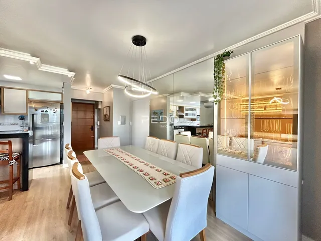 Sala de jantar com mesa e cadeiras em um ambiente claro.
