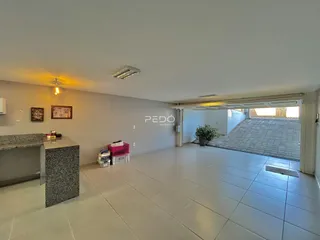 Sala de estar com piso de cerâmica clara e parede branca.