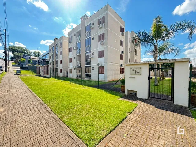 Fachada de um conjunto residencial em Lajeado, Brasil, com jardim e calçada.