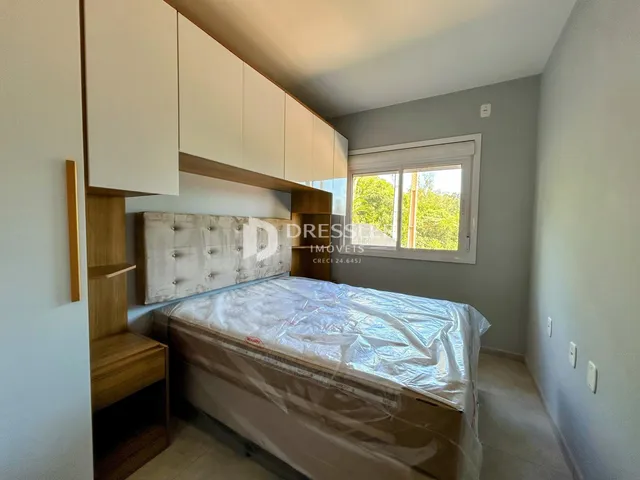 Quarto com cabeceira de madeira e armários em um apartamento no Brasil.