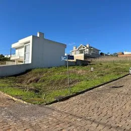 Vista externa da propriedade mostrando uma área de grama e pavimento.