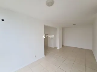 Interior de uma sala com paredes brancas e piso de cerâmica.