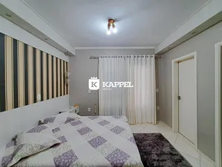 Quarto com cama e parede listrada em um imóvel.