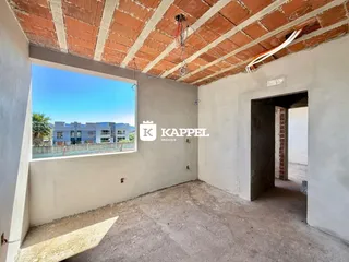 Foto de um ambiente interno com teto de tijolos expostos e uma grande janela.