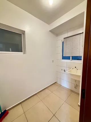 Foto de um corredor interno com piso de cerâmica e janela.