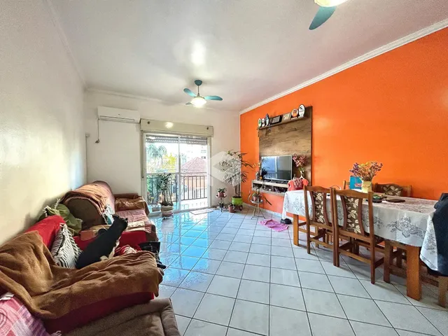 Sala de estar com parede laranja e piso de cerâmica em um imóvel em Lajeado.
