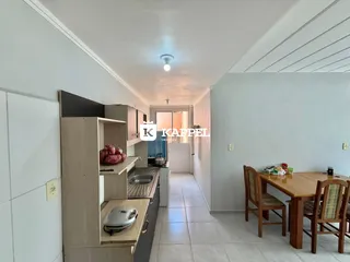 Foto de uma cozinha com armários e uma mesa de jantar em um imóvel.