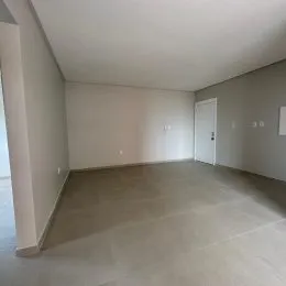 Foto de um ambiente interno amplo com piso claro e paredes brancas.