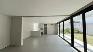 Ambiente interno moderno com piso de porcelanato e grandes janelas.