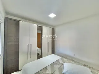 Quarto com guarda-roupas embutidos e cama de casal.