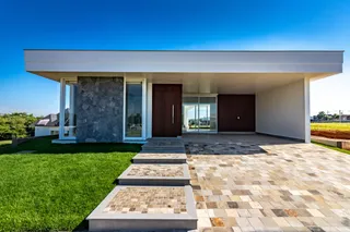 Fachada moderna de uma residência em Lajeado, Brasil, com área externa pavimentada.