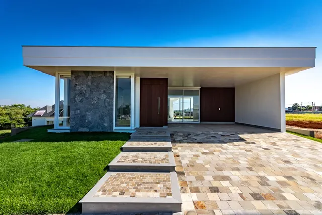 Fachada moderna de uma residência em Lajeado, Brasil, com área externa pavimentada.