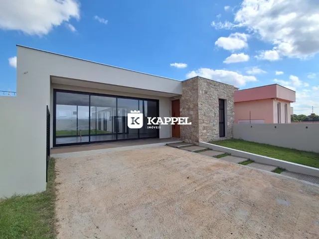 Fachada moderna de uma residência com grandes painéis de vidro e área externa.