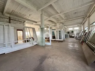 Interior de um espaço amplo e em construção com teto de madeira exposto.