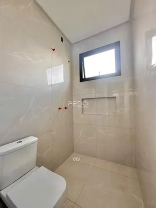 Foto de um banheiro com revestimento de azulejos claros.