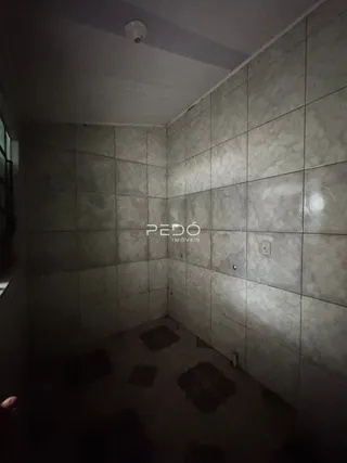 Hall de corredor com paredes e piso revestidos de cerâmica.