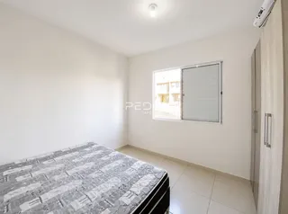 Quarto com cama e janela em ambiente claro.