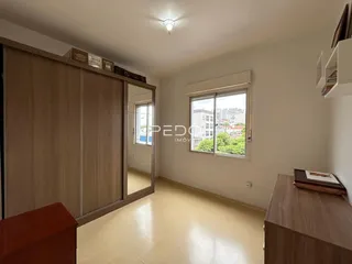 Interior de um cômodo com armários em madeira e janela.